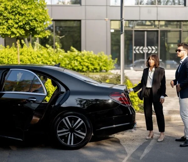 businessman-female-chauffeur-near-car-outdoors